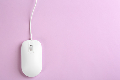 Photo of Modern wired optical mouse on lilac background, top view. Space for text