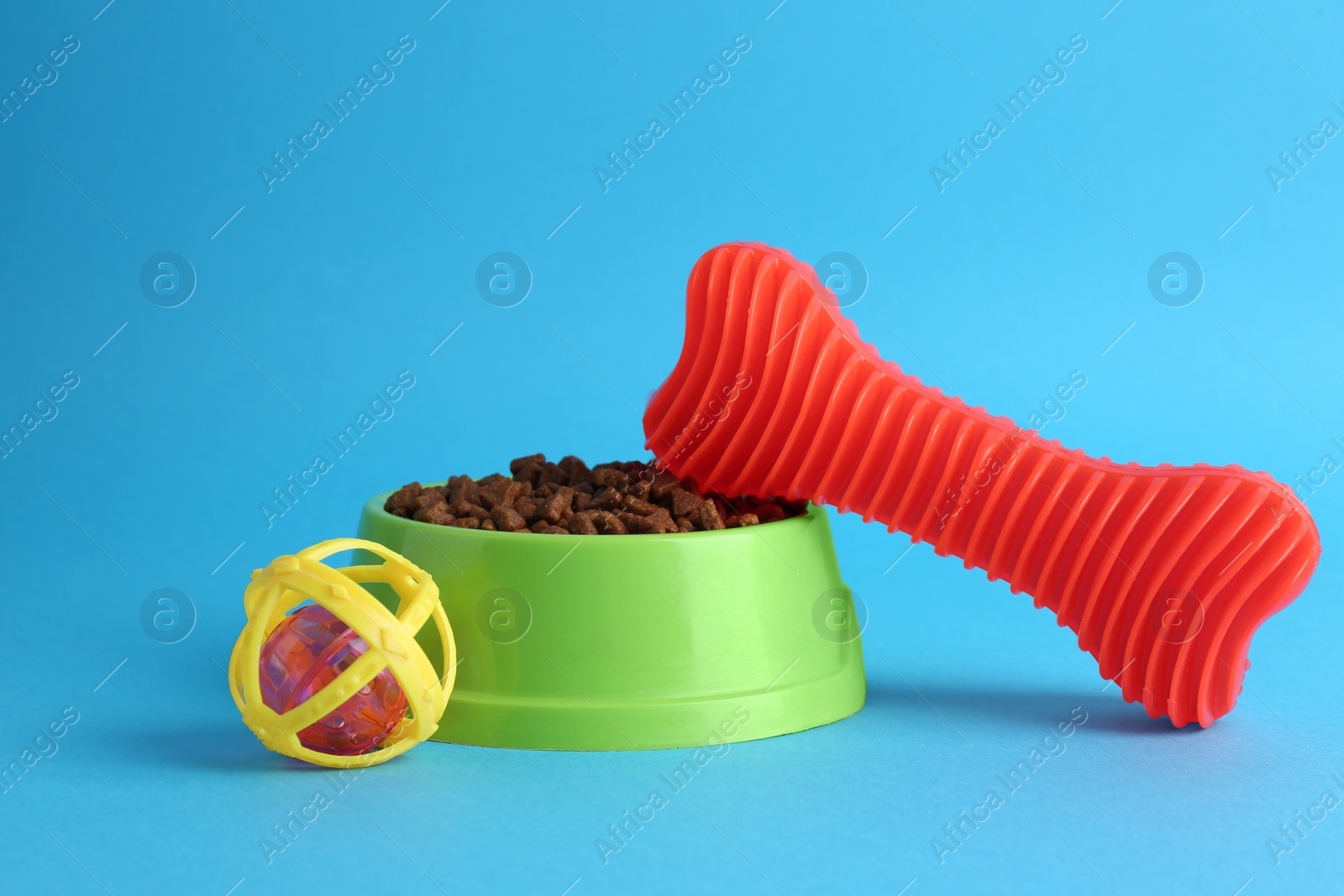 Photo of Pet toys and feeding bowl on light blue background