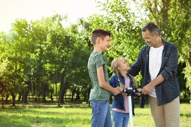 Male pensioner with grandchildren in park. Space for text