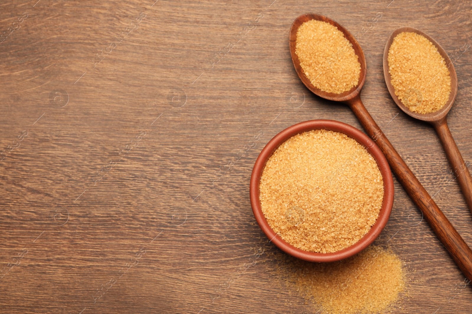 Photo of Brown sugar on wooden table, flat lay. Space for text