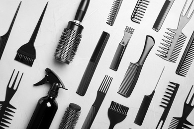 Flat lay composition with hair brushes and combs on light  grey stone background