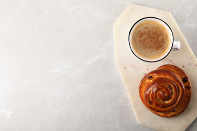 Photo of Delicious coffee and bun on marble table, top view with space for text. Sweet pastries