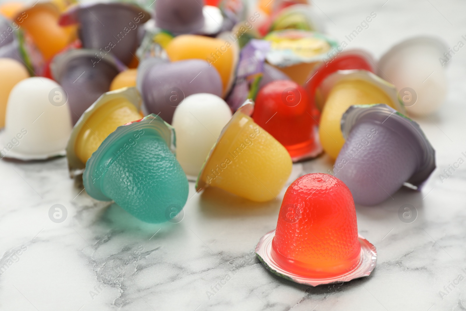 Photo of Tasty bright jelly cups on white marble table