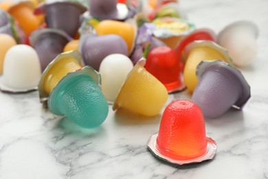 Photo of Tasty bright jelly cups on white marble table