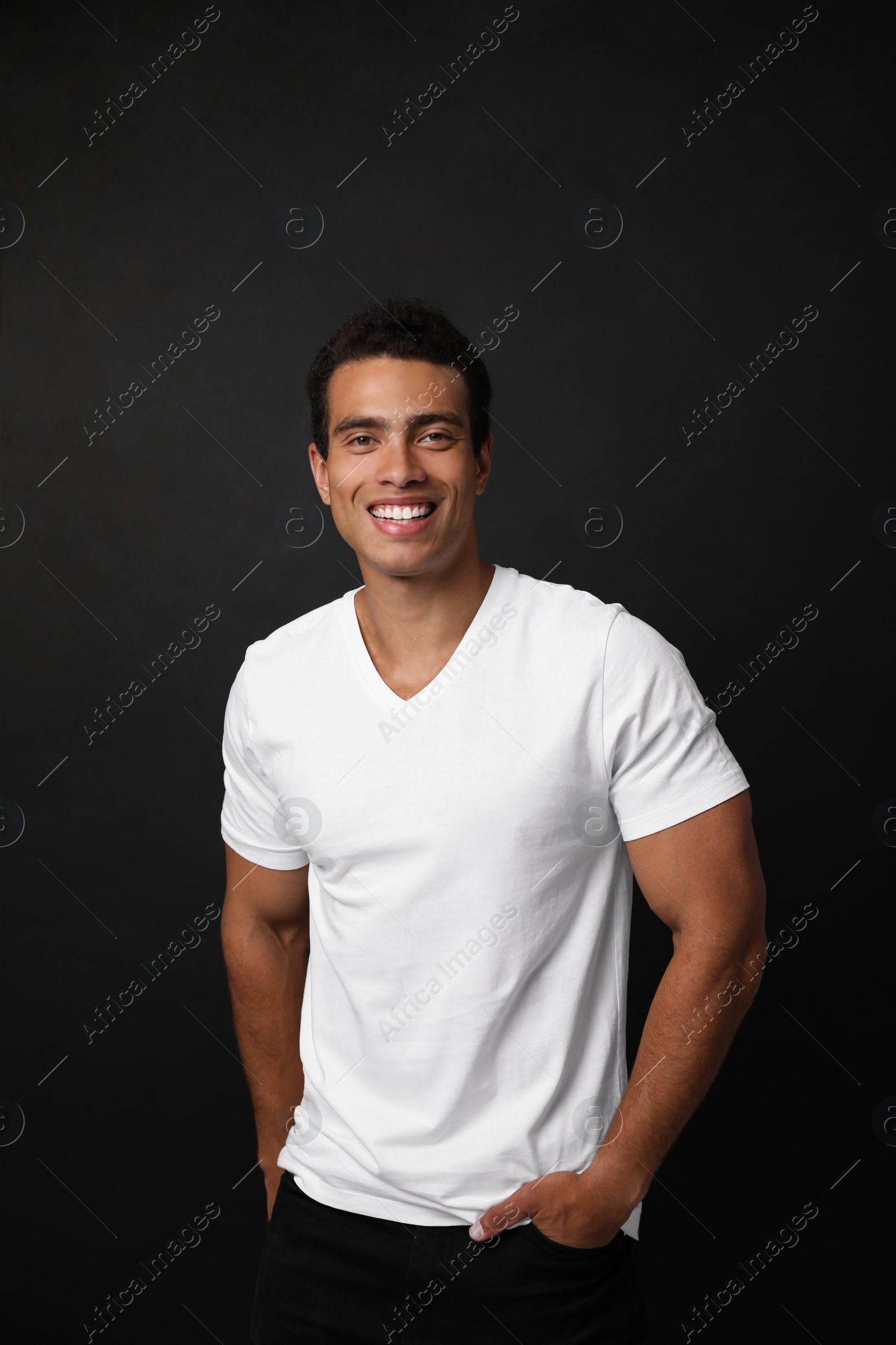 Photo of Handsome young African-American man on black background