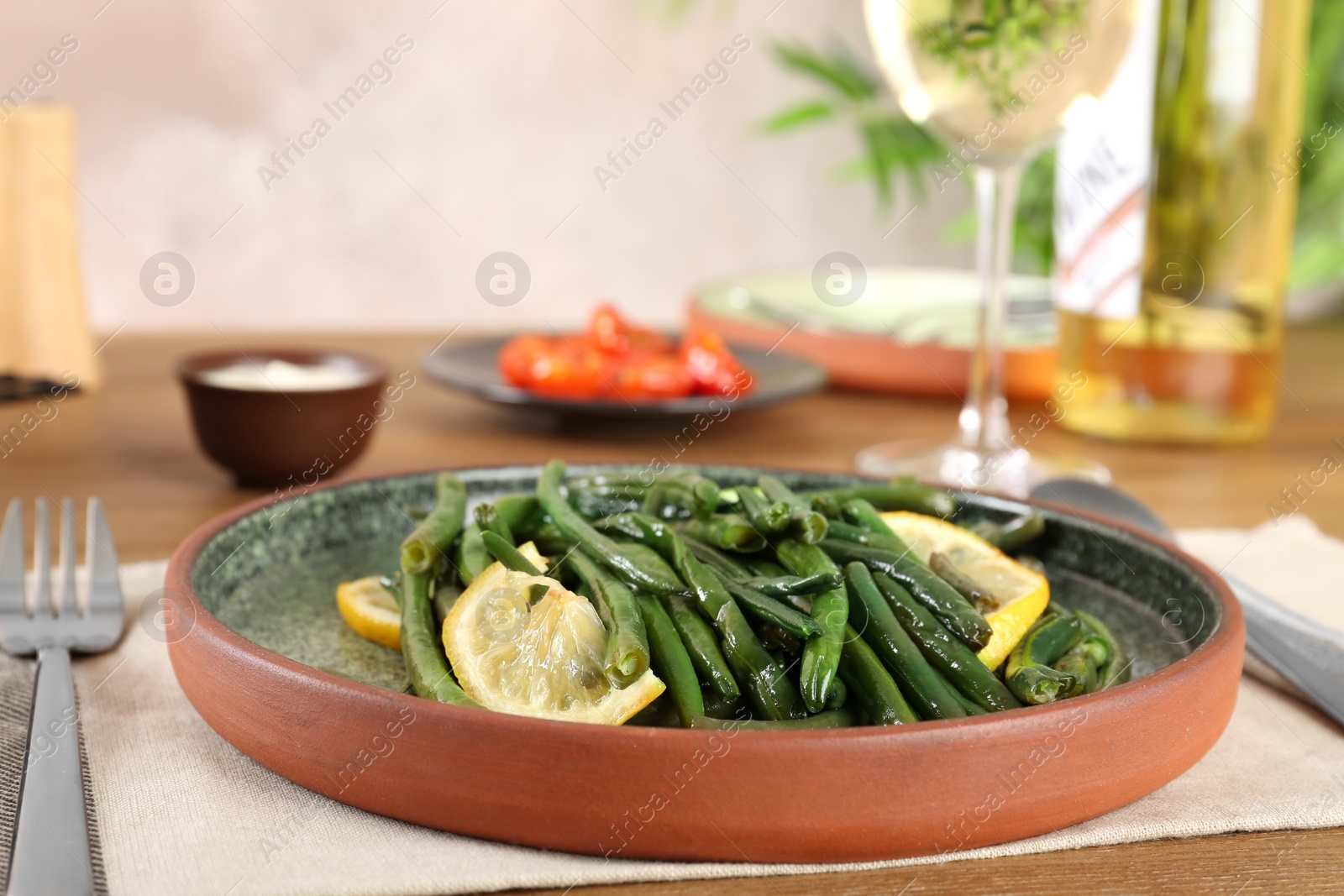 Photo of Delicious green beans with lemon served for dinner on table