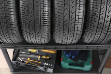 Car tires on shelf in automobile service center, closeup