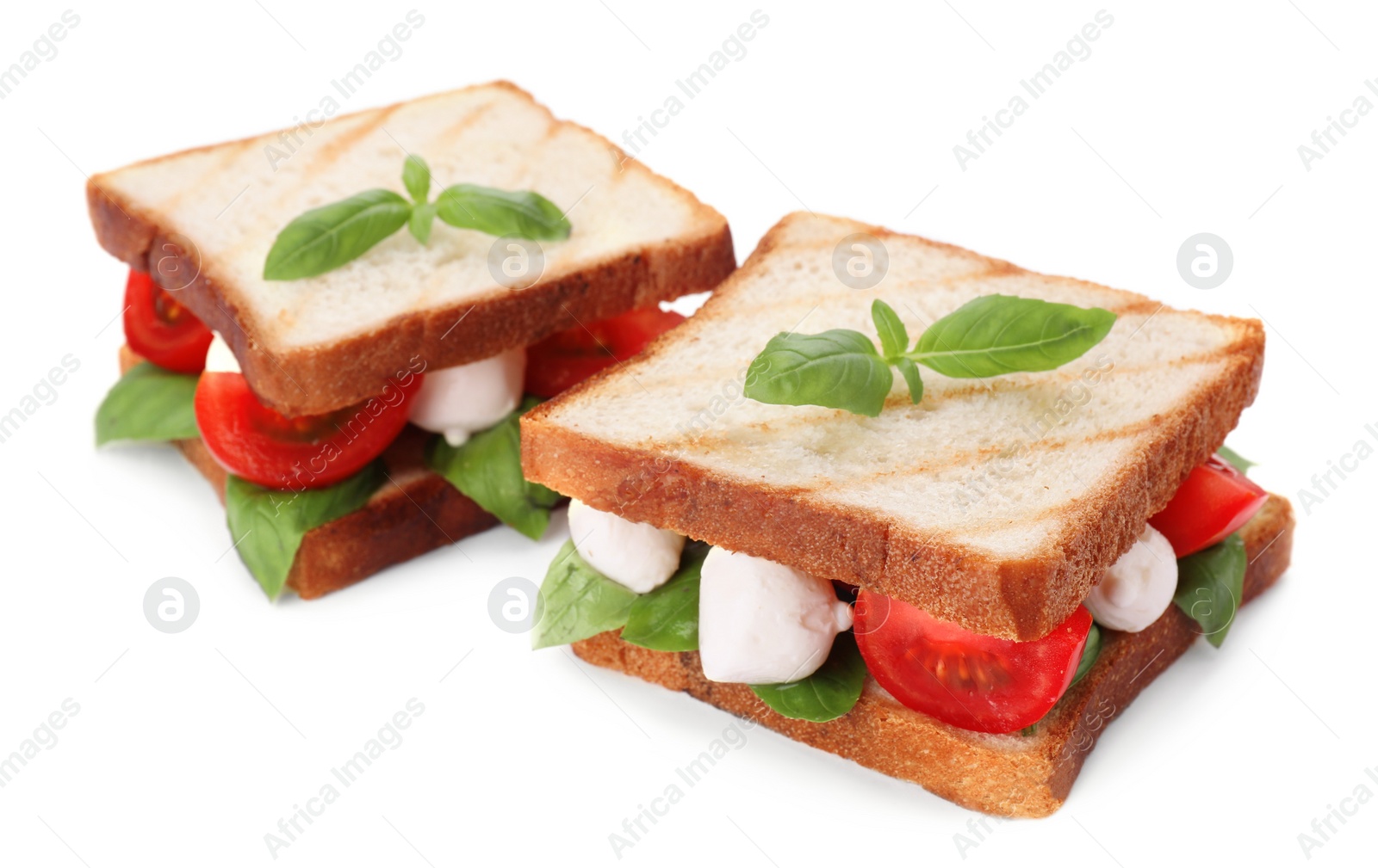 Photo of Delicious Caprese sandwiches with mozzarella, tomatoes, basil and pesto sauce isolated on white