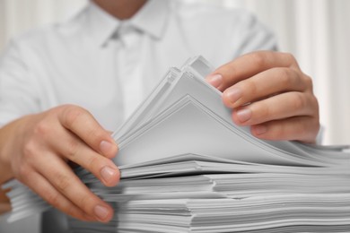 Photo of Man stacking documents in office, closeup view
