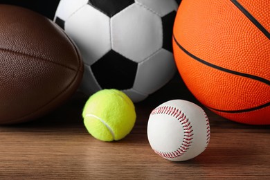 Photo of Set of different sport balls on wooden surface, closeup