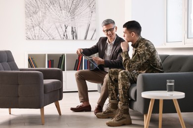 Photo of Professional psychotherapist working with military man in office