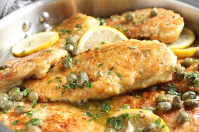 Photo of Delicious chicken piccata with herbs in pot, closeup