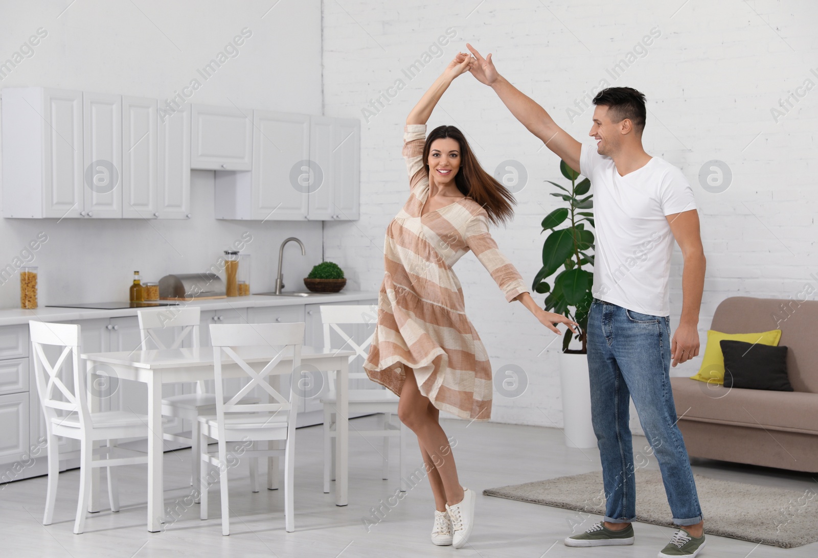 Photo of Happy couple dancing in kitchen at home