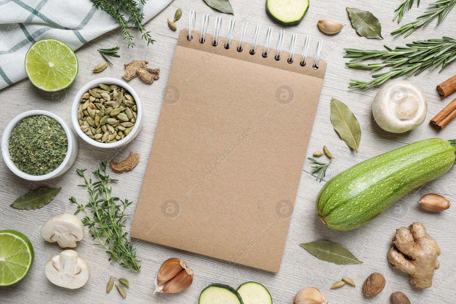 Photo of Open recipe book and different ingredients on white wooden table, flat lay. Space for text