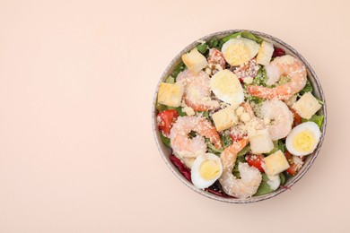 Photo of Delicious Caesar salad with shrimps on beige background, top view. Space for text