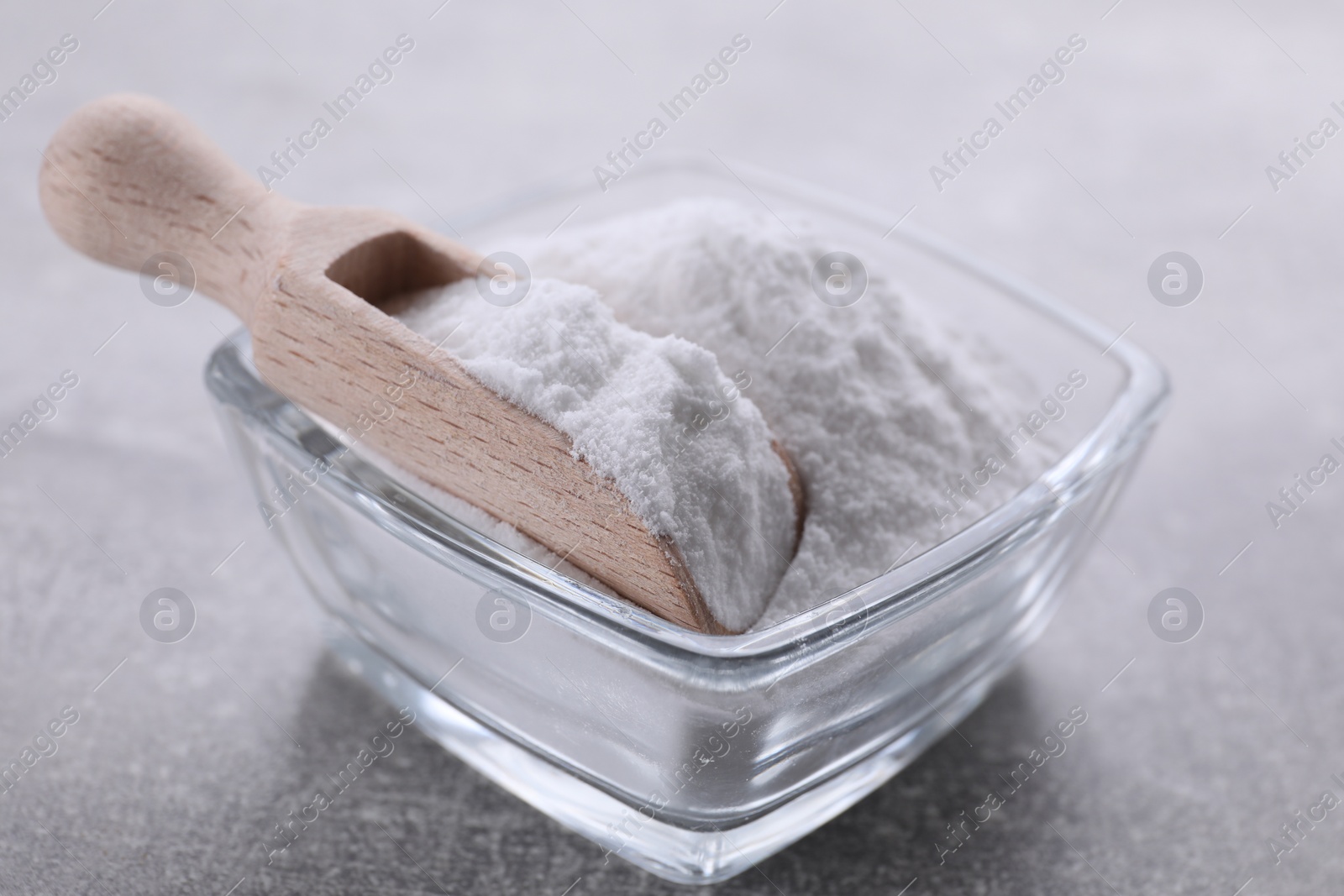 Photo of Bowl of sweet fructose powder on light grey table, closeup