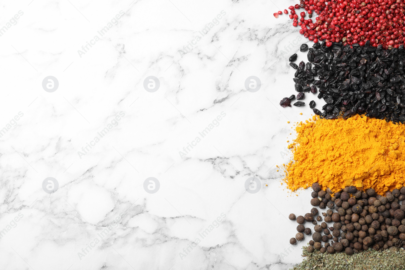 Photo of Many different spices on white marble background, top view. Space for text