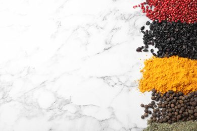 Photo of Many different spices on white marble background, top view. Space for text