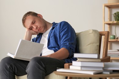 Photo of Tired man studying in armchair at home