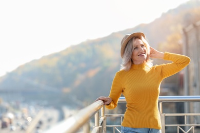 Portrait of happy mature woman on balcony, outdoors