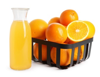 Fresh oranges in metal basket and bottle of juice isolated on white