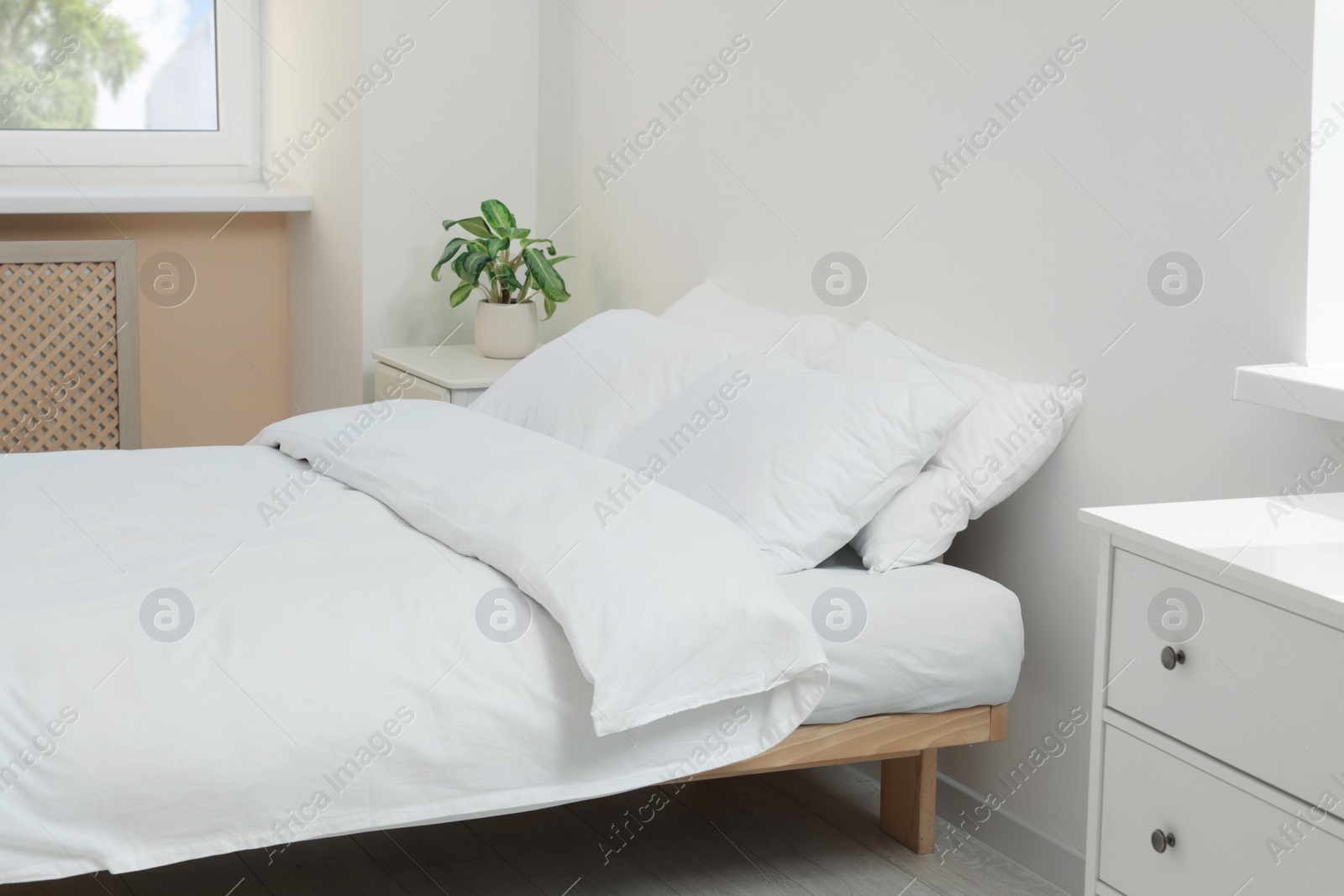 Photo of Bed with soft white pillows in cozy room interior