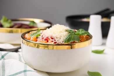 Photo of Delicious pasta with tomato sauce, basil and parmesan cheese on white table