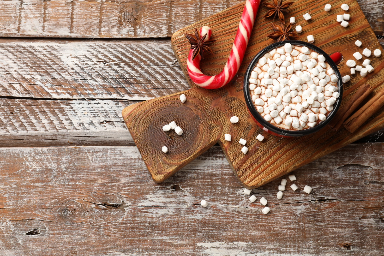 Photo of Tasty hot chocolate with marshmallows on wooden table, top view. Space for text