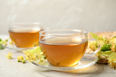 Tasty tea and linden blossom on light grey table