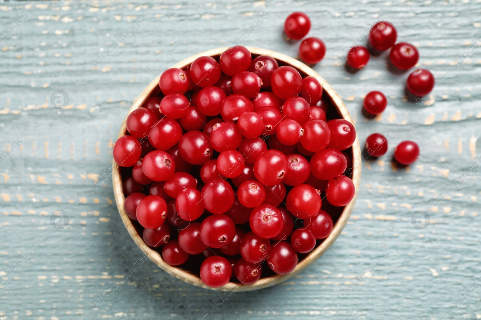 Photo of Tasty ripe cranberries on grey wooden table, flat lay