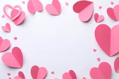 Photo of Frame of pink paper hearts on white background, flat lay. Space for text