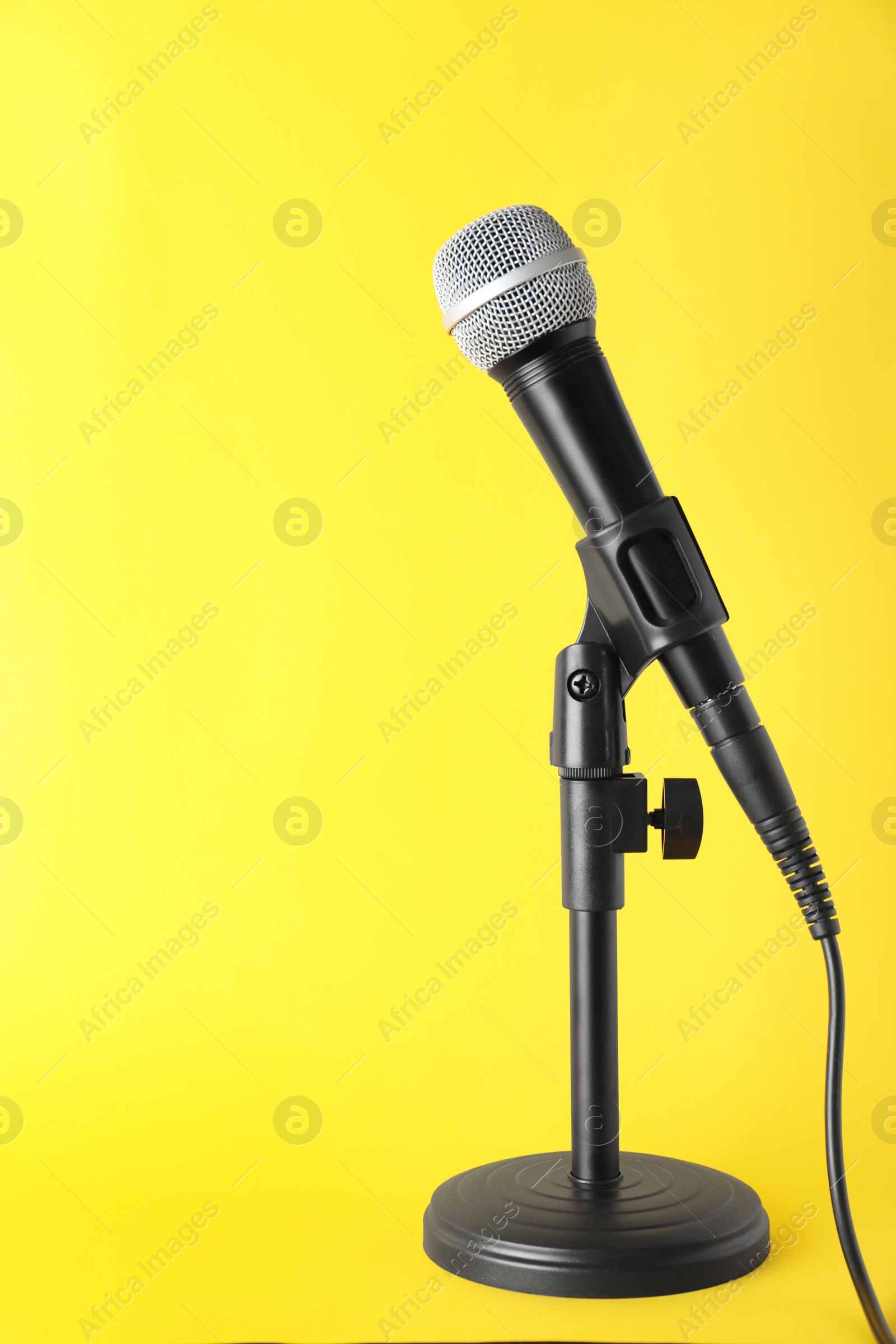 Photo of Dynamic microphone on color background, space for text