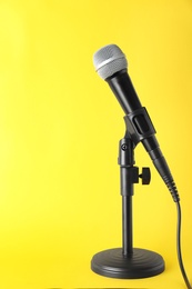 Photo of Dynamic microphone on color background, space for text