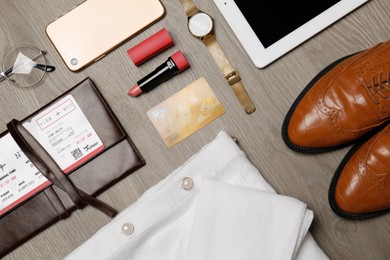 Flat lay composition with clothes, shoes and accessories on wooden background. Packing for business trip