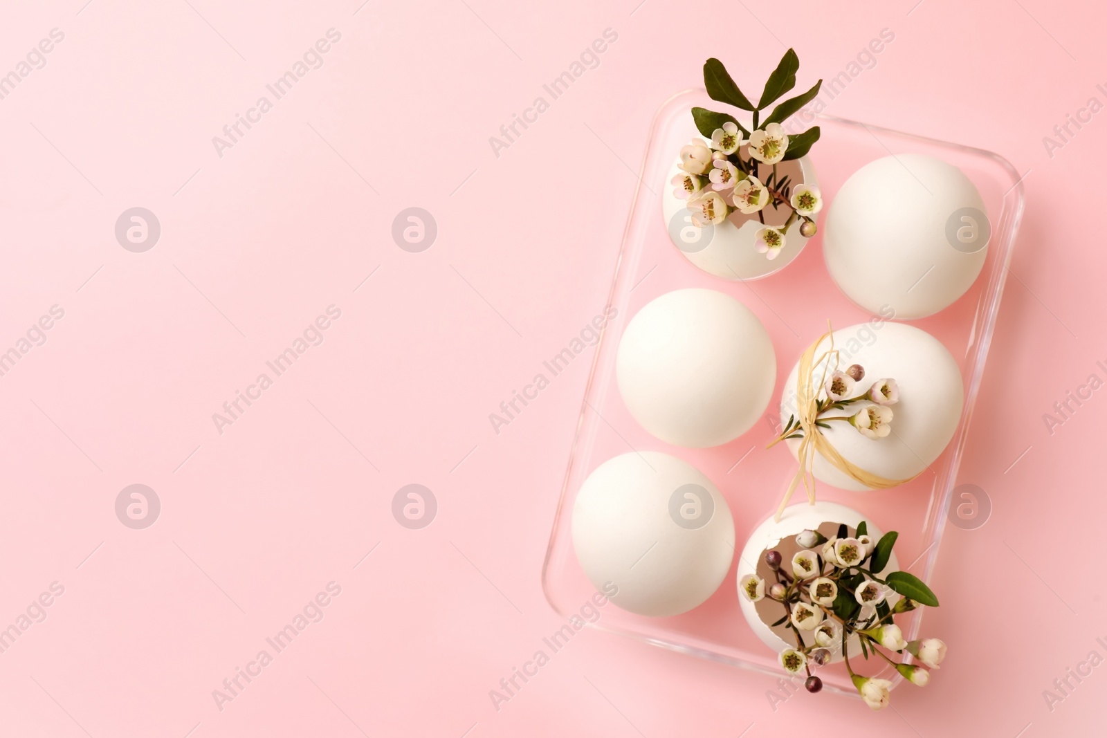 Photo of Happy Easter. Festive composition with eggs and floral decor on pink background, top view. Space for text