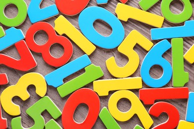 Colorful numbers on wooden school desk, top view