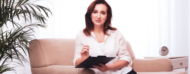 Image of Portrait of psychotherapist with clipboard on sofa in office. Banner design