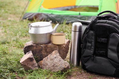 Photo of Backpack and set of dishware for camping outdoors