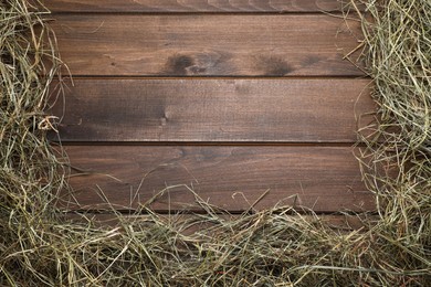 Photo of Frame made of dried hay on wooden table, top view. Space for text