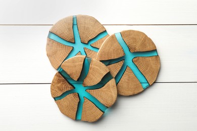 Stylish wooden cup coasters on white table, top view