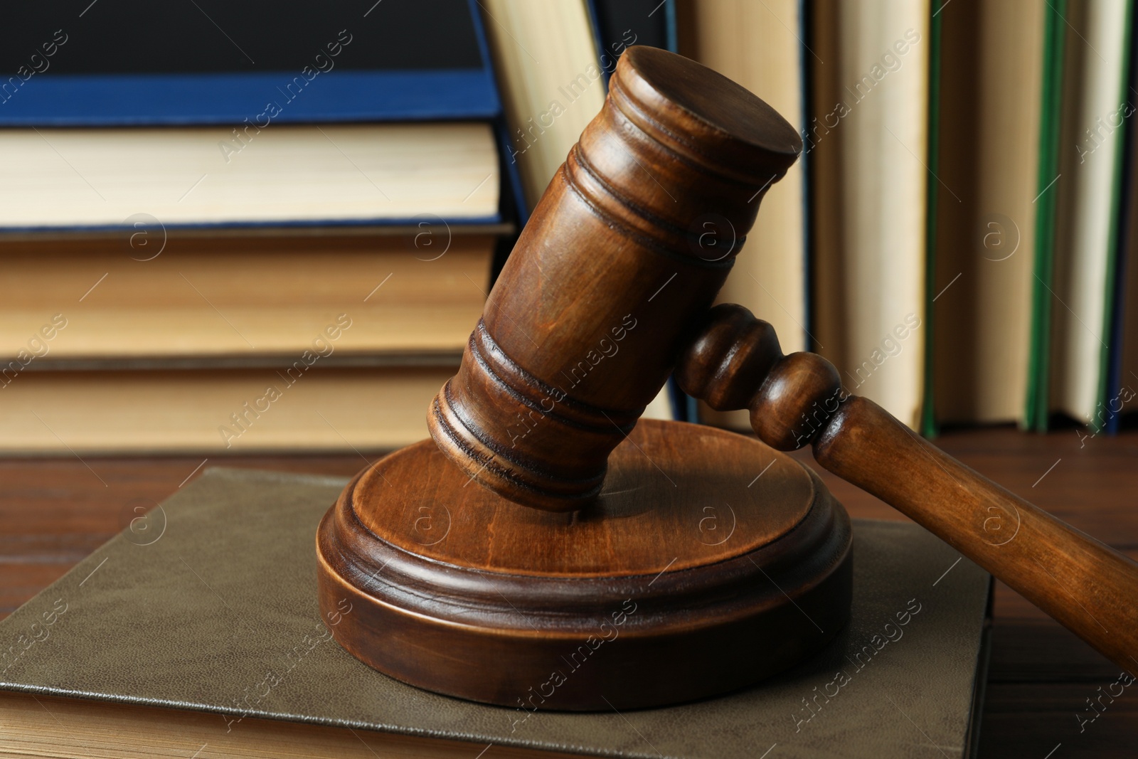 Photo of Wooden gavel and books on table, closeup. Law concept