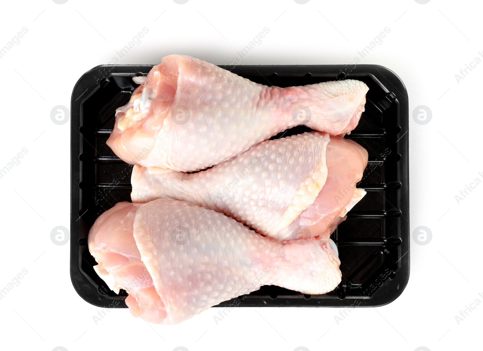 Photo of Plastic container with raw chicken drumsticks on white background, top view. Fresh meat