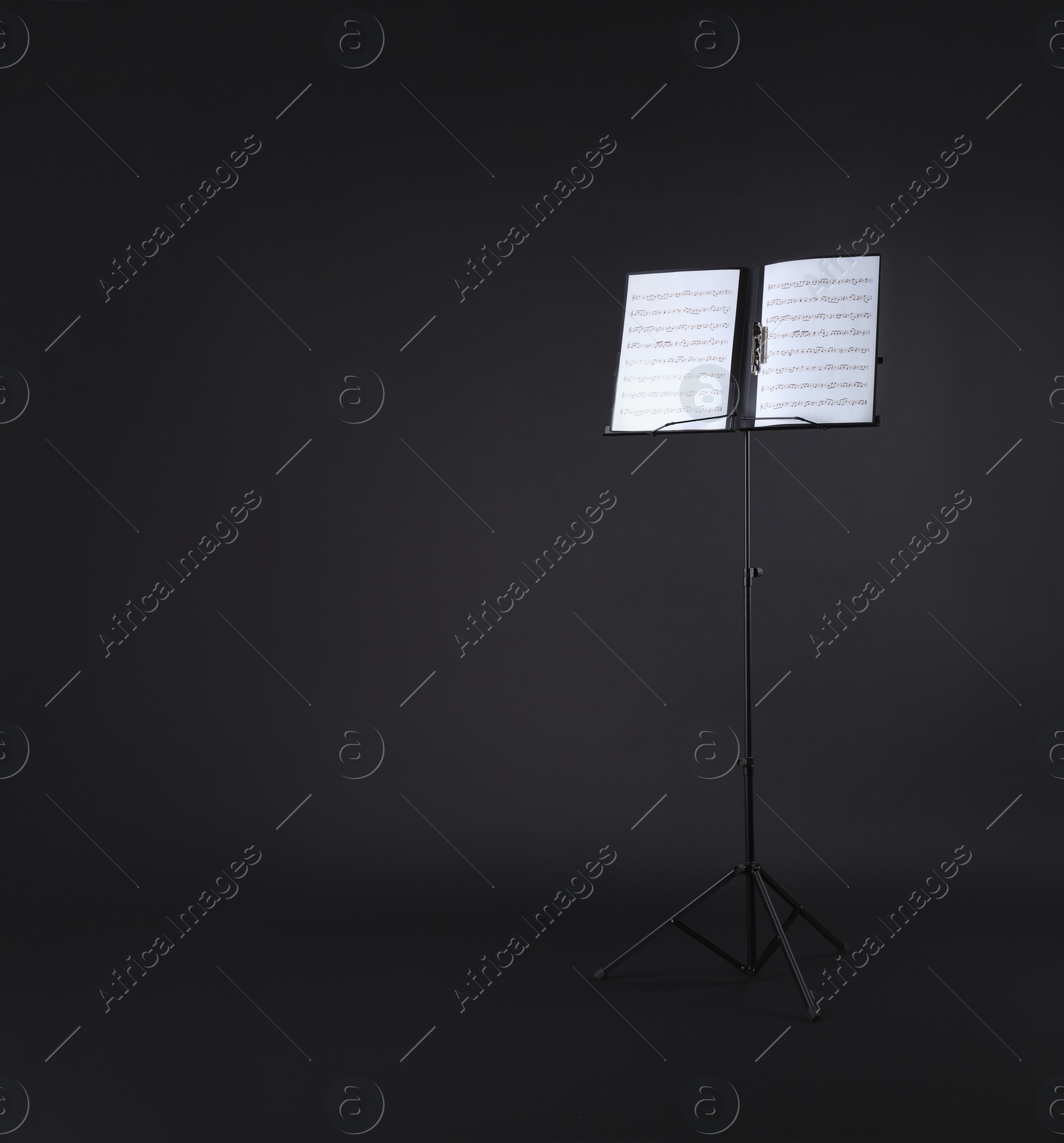 Photo of Note stand with music sheets on black background. Space for text