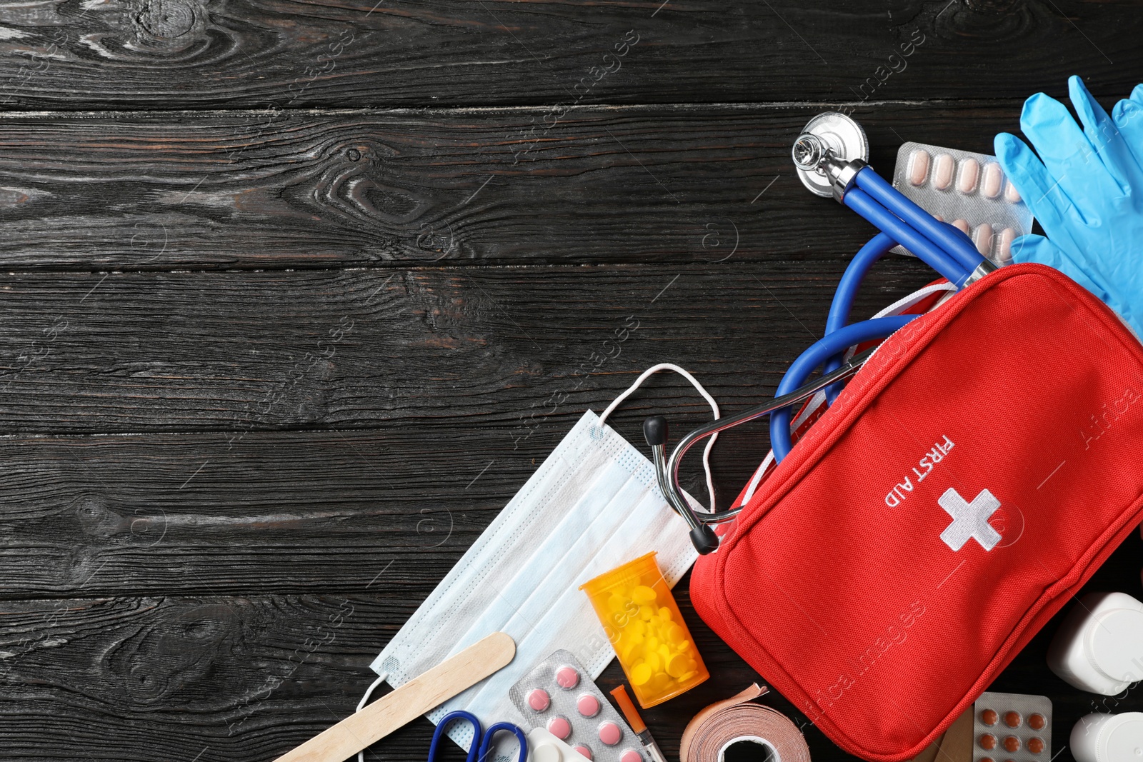 Photo of Flat lay composition with first aid kit and space for text on dark background