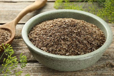 Dry seeds and fresh dill on wooden table, closeup