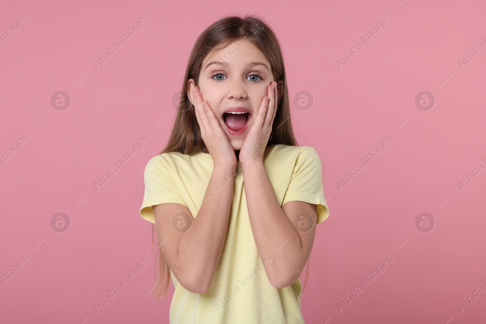 Photo of Portrait of surprised girl on pink background