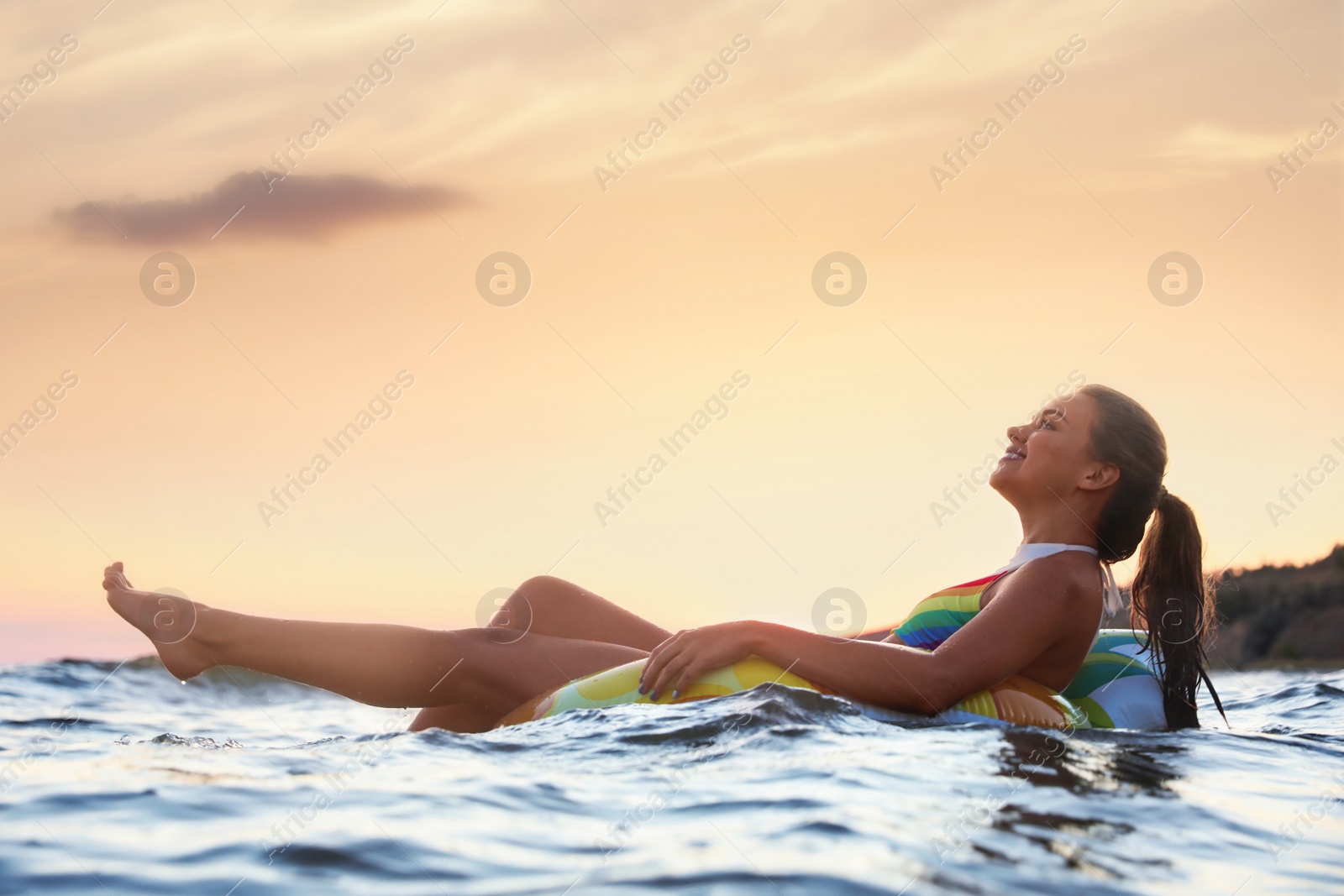 Photo of Young woman on inflatable ring in water