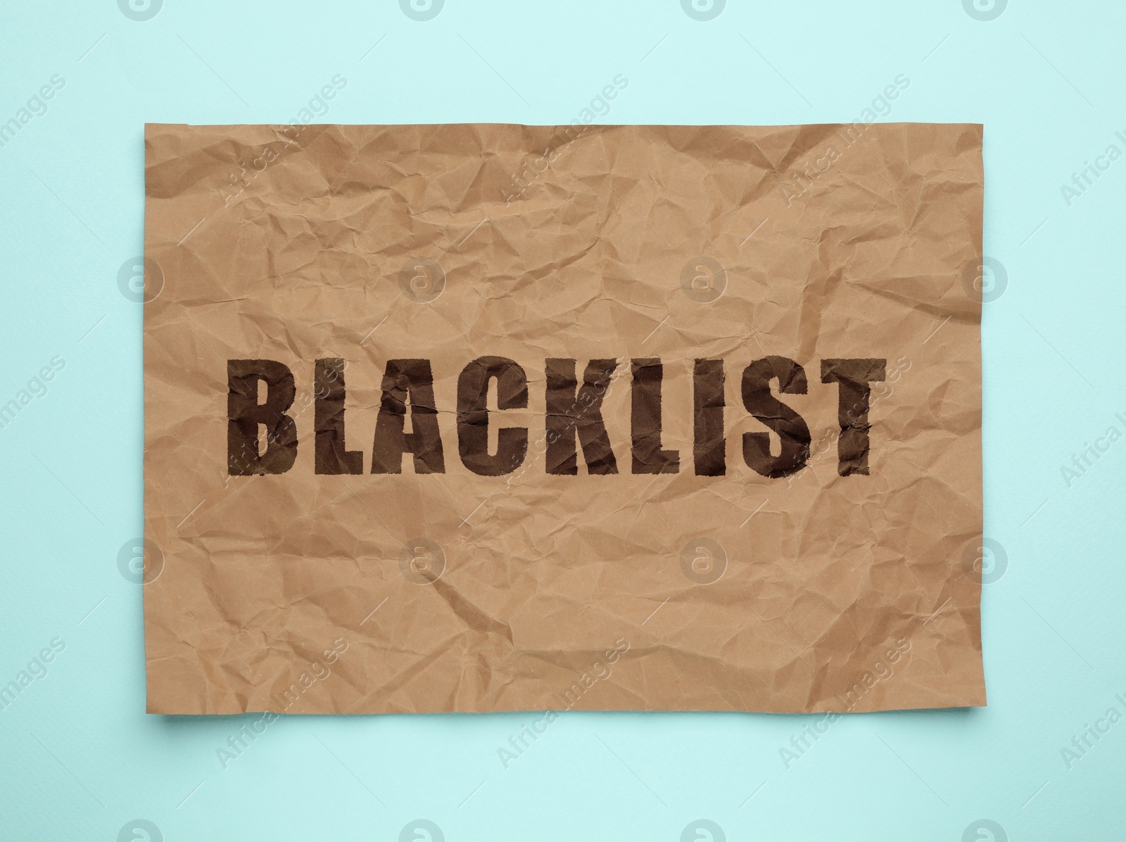 Image of Crumpled paper with word Blacklist on light blue background, top view