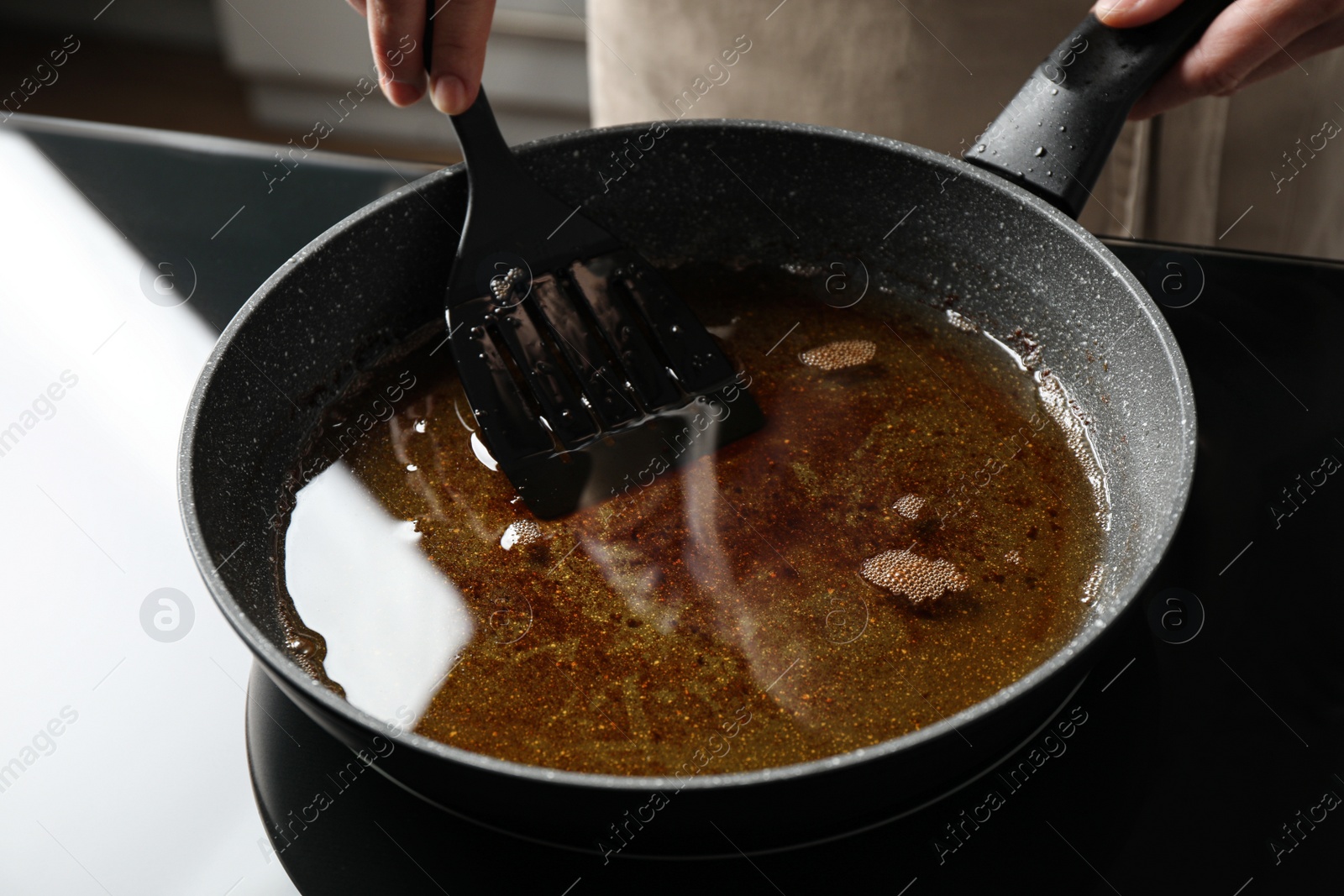 Photo of Woman holding frying pan with used cooking oil, closeup