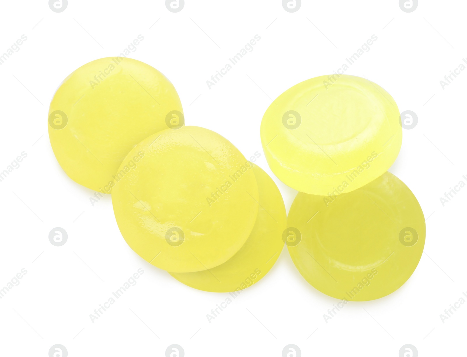 Photo of Many yellow cough drops on white background, top view